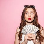 お札を持ってウキウキしている女性